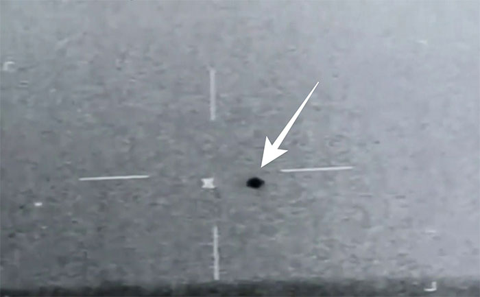 UFO là một đốm gần tròn sẫm màu nằm phía trên đường chân trời.