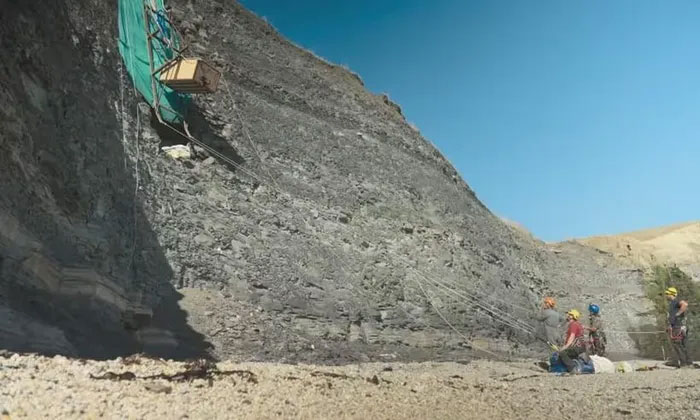  Các nhà sinh vật học đu trên dây để khai quật hóa thạch trên vách đá dựng đứng