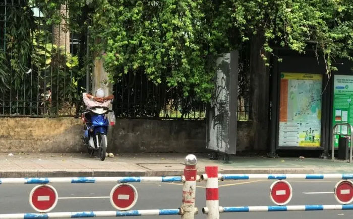 Người lái xe ôm ngủ trên chiếc xe máy ở Việt Nam.