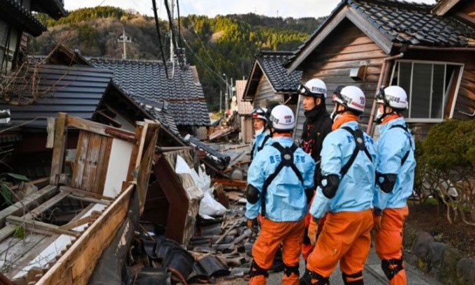 Lính cứu hỏa kiểm tra những ngôi nhà gỗ bị sụp đổ ở thành phố Wajima trên bán đảo Noto