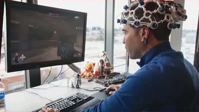 Mike Ambinder chơi game khi đeo trên đầu thiết bị liên kết não bộ - máy tính do OpenBCI thiết kế chế tạo.